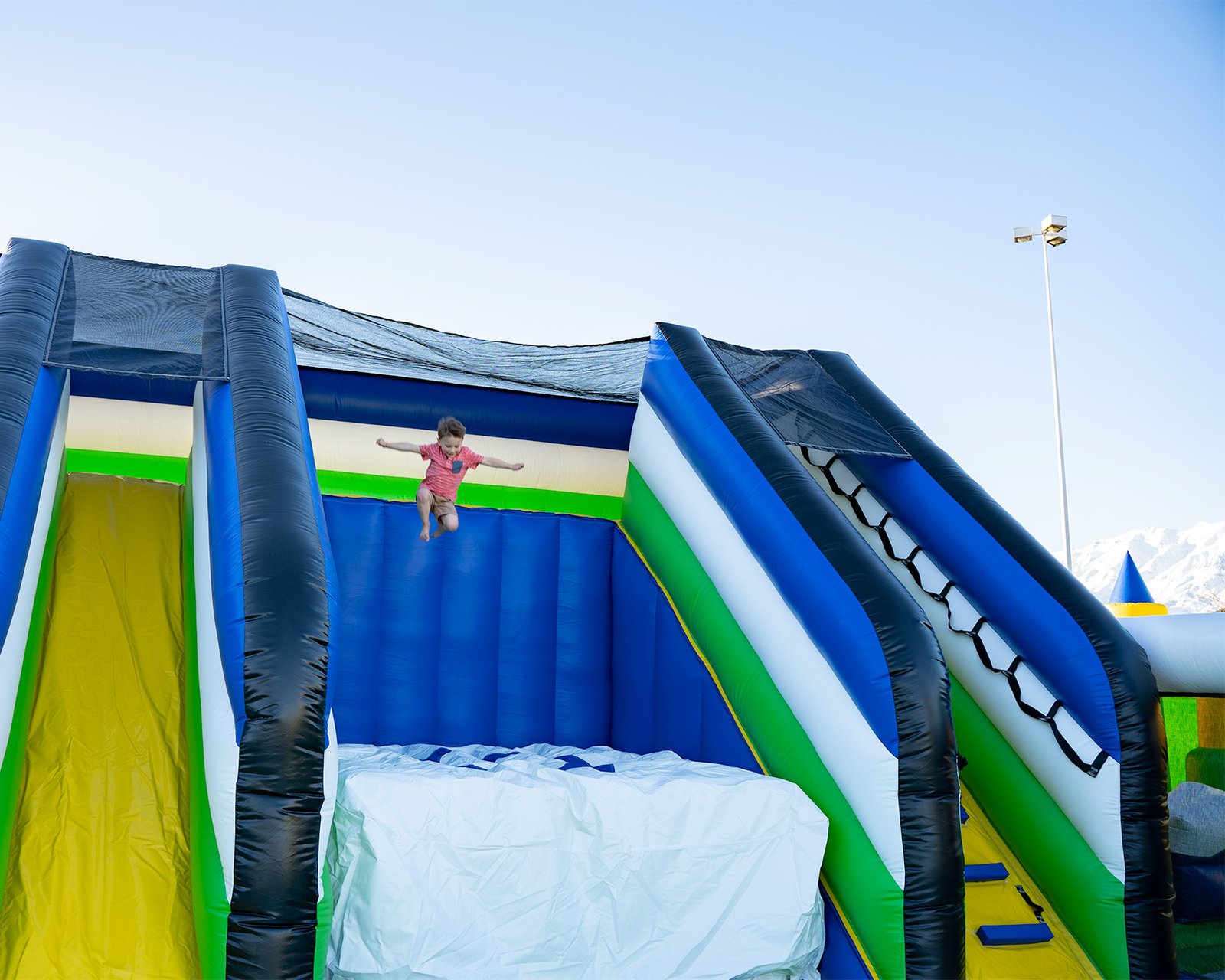 Boy jumping off platform onto a giant air bag at one of the world's largest bounce houses