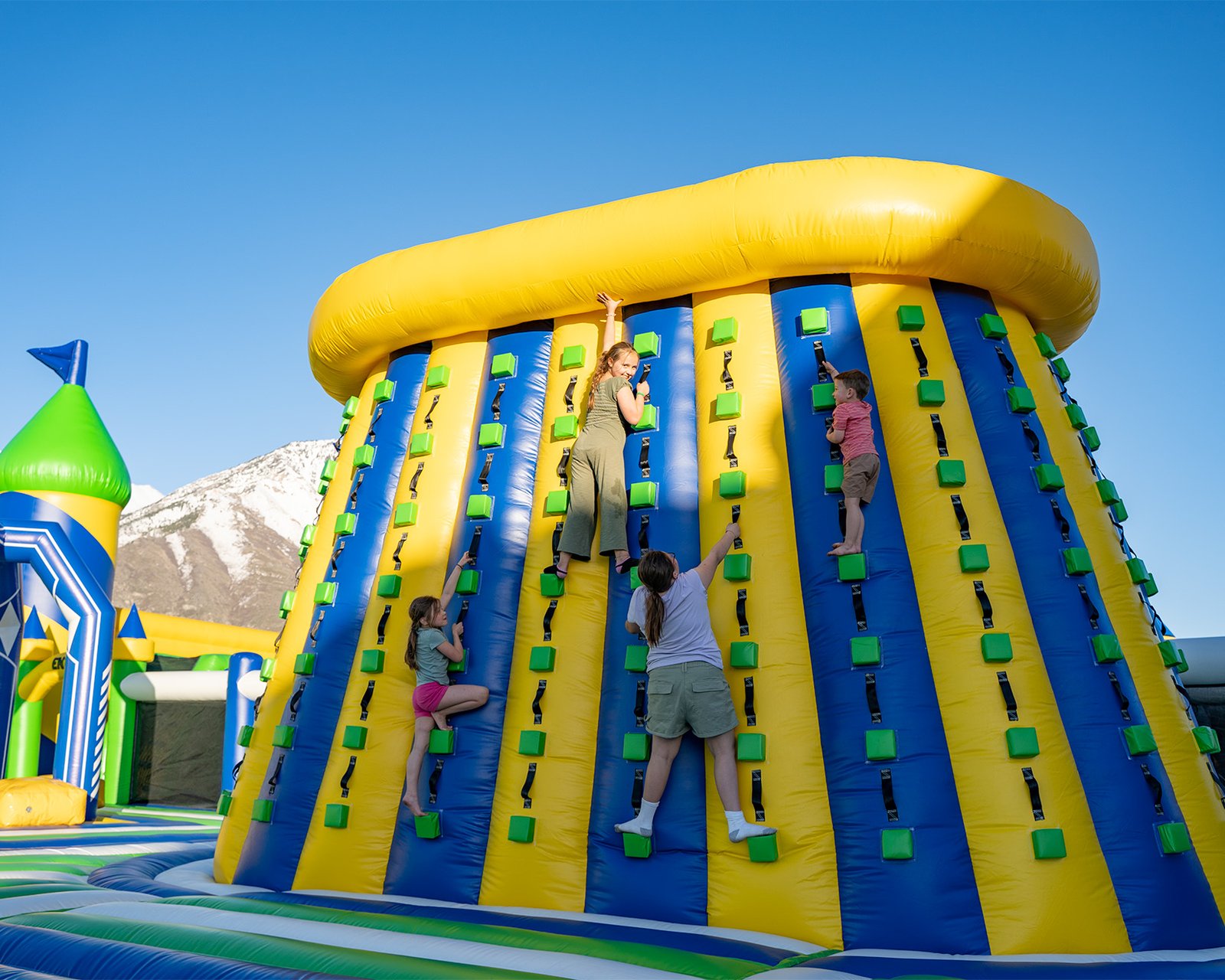 Kids climbing an inflatable climbing wall at one of the world's largest bounce houses