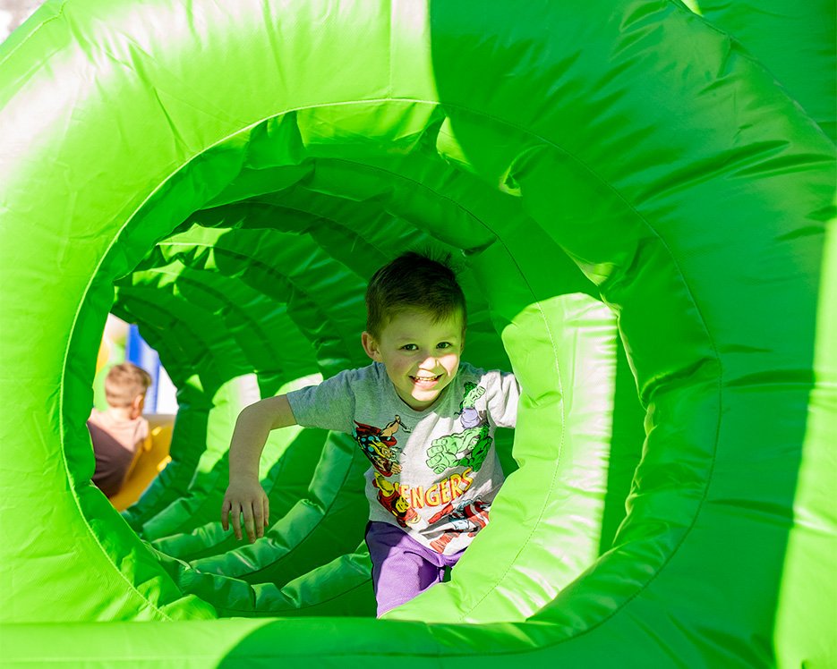 Little boy crawling through obstacle course at one of the world's largest bounce houses