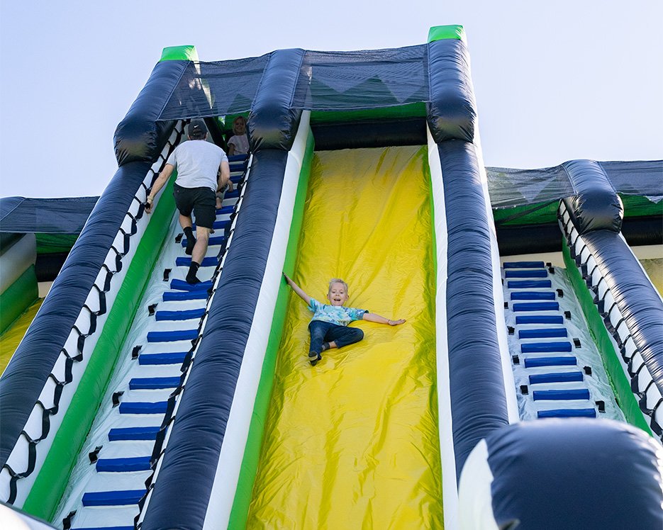 Boy sliding down inflatable slide at one of the world's largest bounce houses