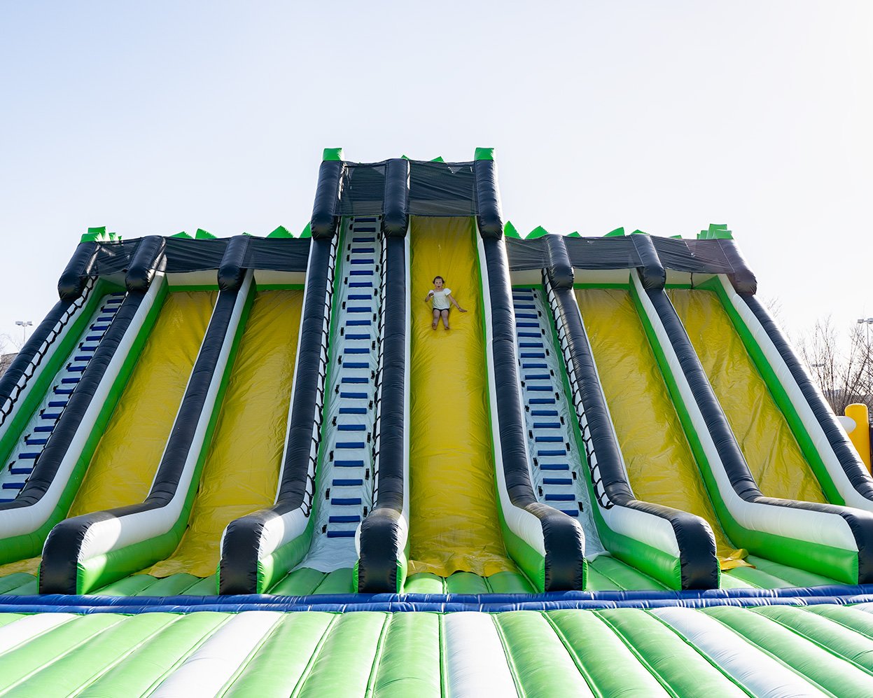 Girl sliding down a giant inflatable slide at one of the world's largest bounce houses