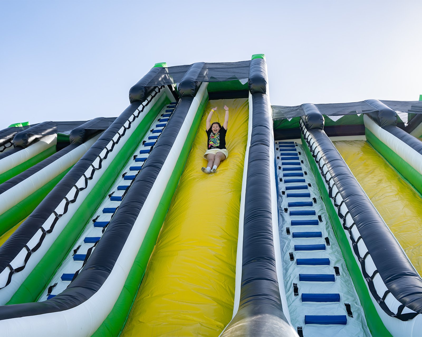 Girl sliding down a giant inflatable slide at one of the world's largest bounce houses